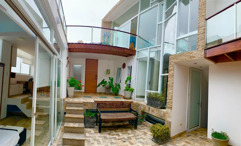 Patio d'entrée dallé, entouré de façades vitrées